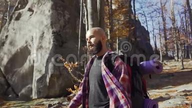 一个长着胡须的英俊青年在温暖的秋日散步。 秋天，一位游客在树林里旅行
